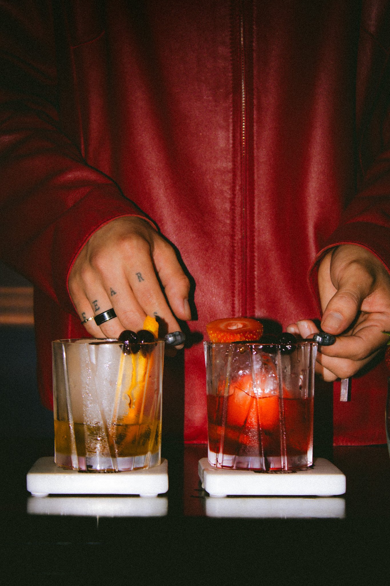 Two old fashioned cocktails garnished and served